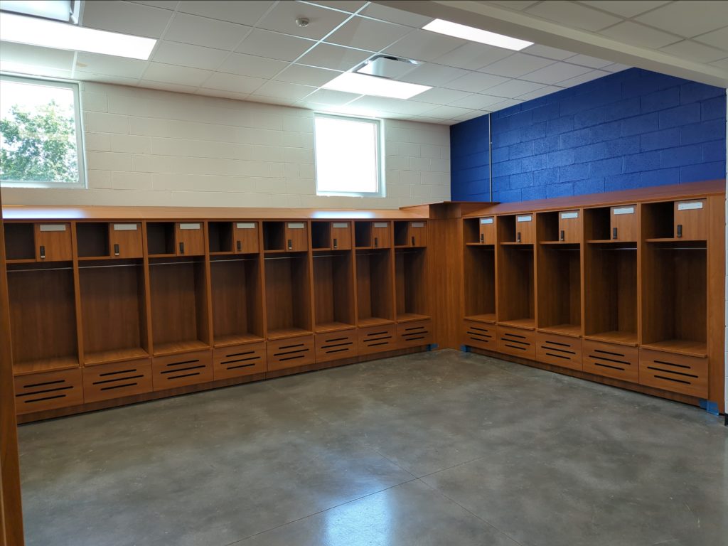 Sports locker room for high school with battery powered locks and extra bench storage