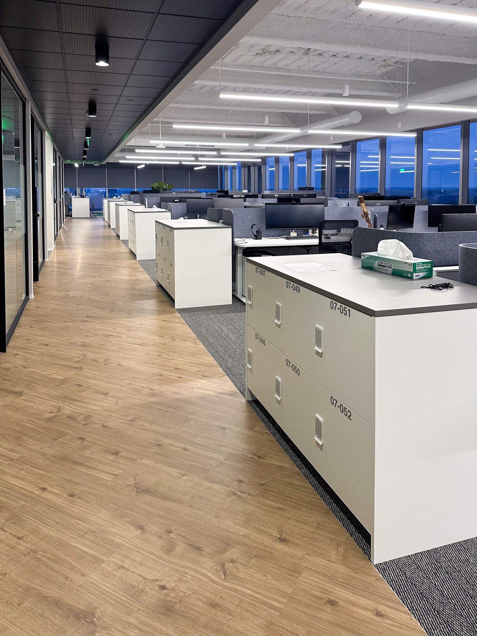 Modern office corridor with white island locker system by HAMILTON Casework Solutions